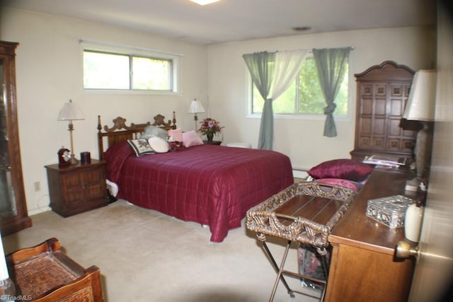 bedroom with a baseboard heating unit and carpet