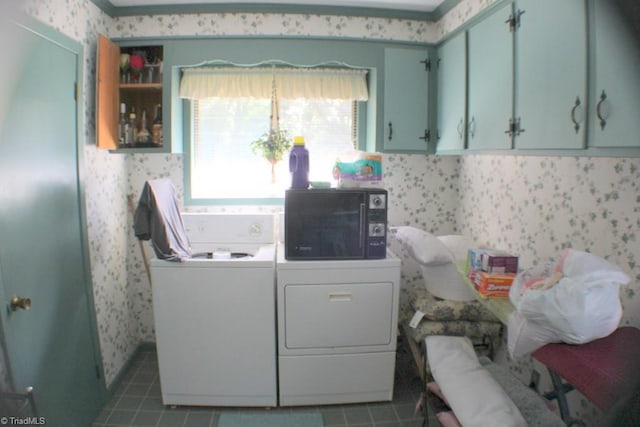 laundry area with cabinets, dark tile patterned flooring, and washing machine and dryer