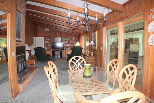 carpeted dining area featuring wooden walls, lofted ceiling with beams, and a chandelier