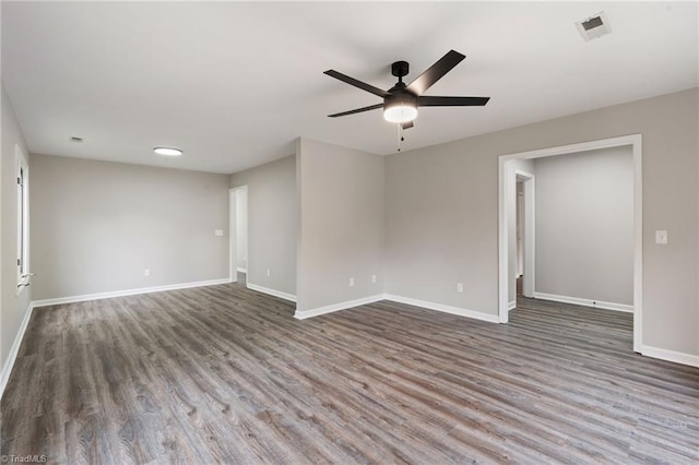 spare room with a ceiling fan, baseboards, visible vents, and wood finished floors