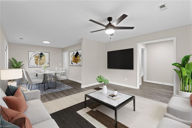 living area featuring ceiling fan, baseboards, visible vents, and wood finished floors