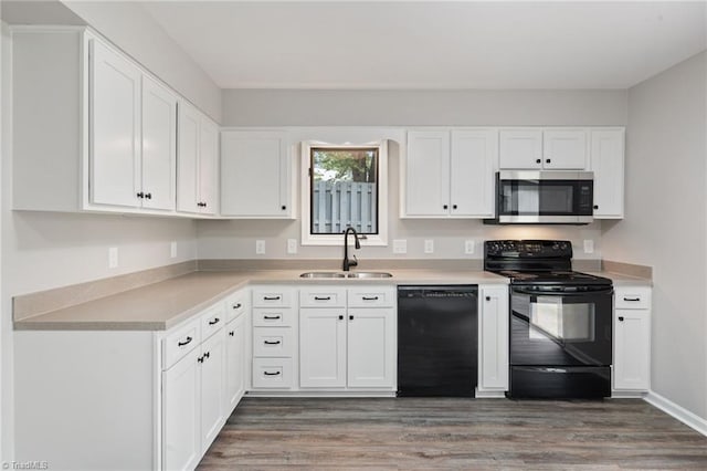 kitchen featuring a sink, white cabinetry, wood finished floors, and black appliances