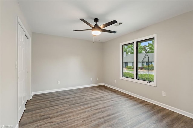 unfurnished bedroom with baseboards, a closet, dark wood-style floors, and visible vents