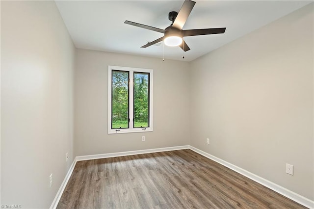 spare room featuring baseboards, ceiling fan, and wood finished floors