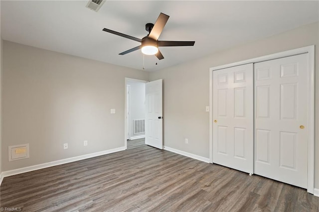 unfurnished bedroom with visible vents, dark wood finished floors, and baseboards