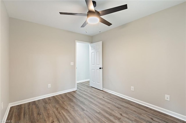 spare room with baseboards, ceiling fan, and wood finished floors