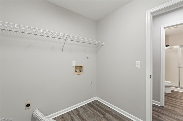 laundry area featuring baseboards, dark wood-type flooring, gas dryer hookup, electric dryer hookup, and washer hookup