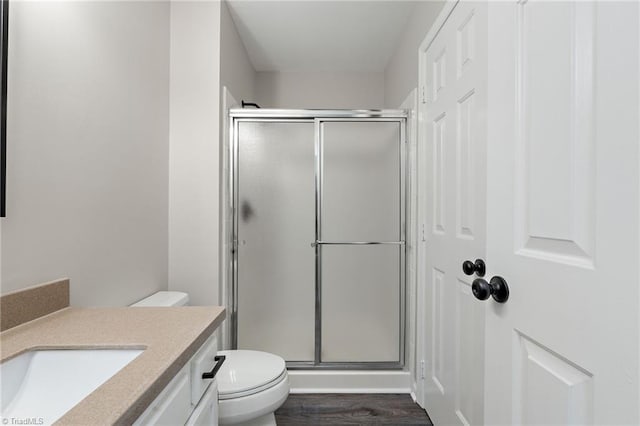 full bathroom with vanity, wood finished floors, toilet, and a shower stall