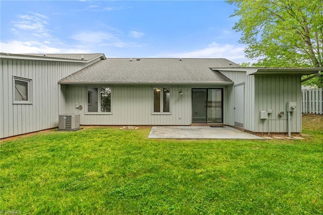 back of house with fence, a patio, central AC unit, a shingled roof, and a lawn