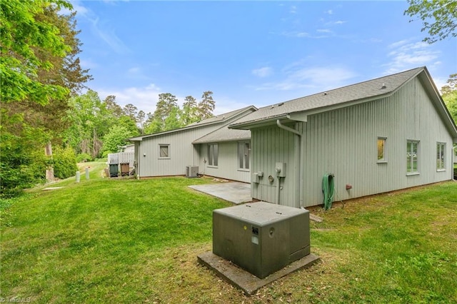 back of property with a lawn, central AC, and a patio