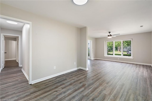 spare room with dark wood-style flooring, baseboards, and a ceiling fan