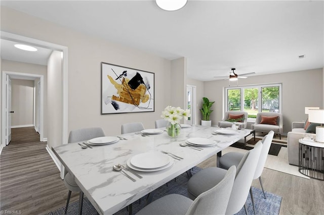 dining space featuring a ceiling fan and wood finished floors