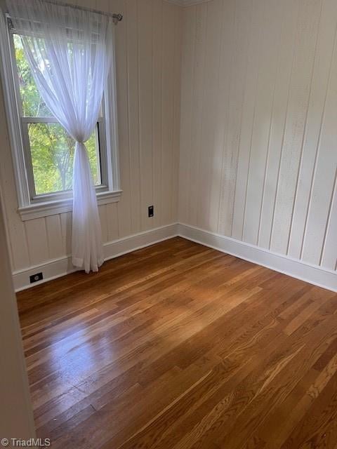 unfurnished room with wood-type flooring