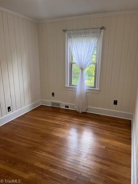 unfurnished room featuring ornamental molding and hardwood / wood-style floors