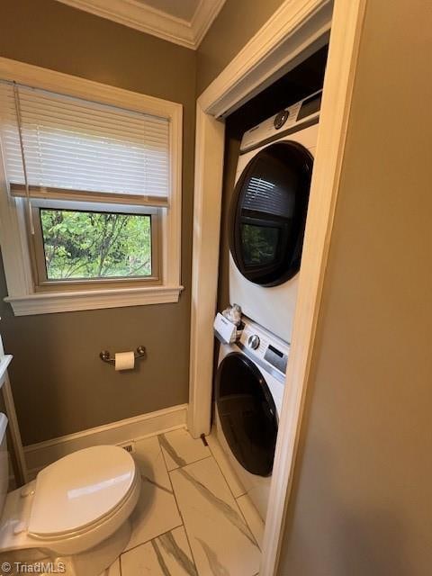 laundry room with light tile patterned flooring, ornamental molding, and stacked washer and dryer