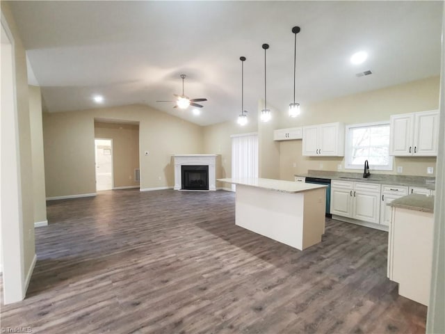 kitchen with sink, a center island, lofted ceiling, white cabinets, and dark hardwood / wood-style floors