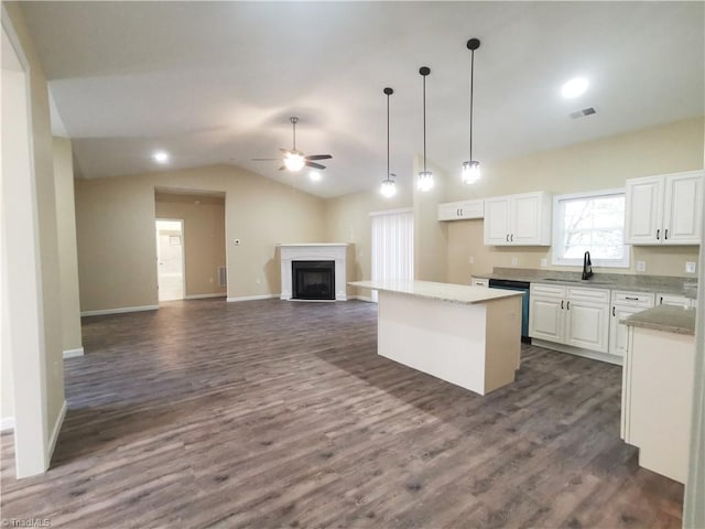 kitchen with lofted ceiling, hanging light fixtures, a kitchen island, white cabinetry, and dark hardwood / wood-style floors