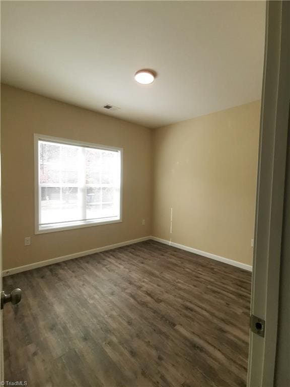 spare room with dark hardwood / wood-style flooring