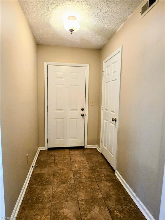 doorway with a textured ceiling