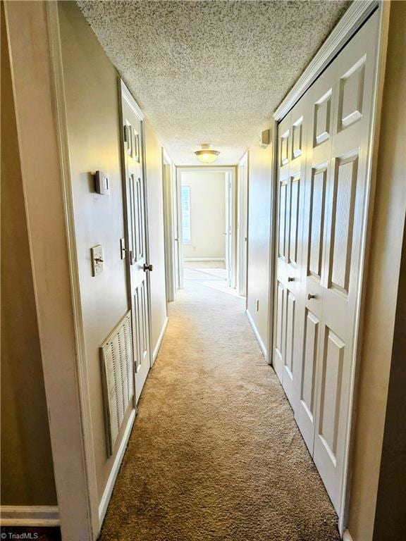 corridor featuring carpet and a textured ceiling