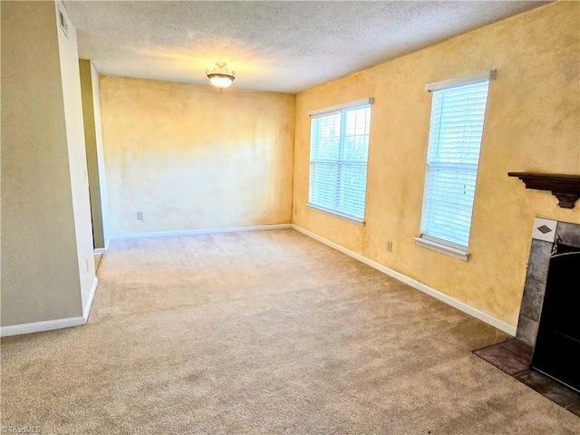 unfurnished living room with a fireplace, a textured ceiling, and carpet flooring