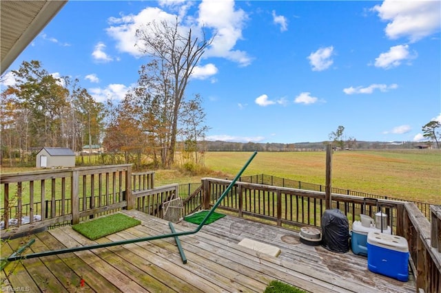 deck with a storage unit, a yard, and a rural view