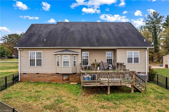 rear view of house featuring a lawn and a deck