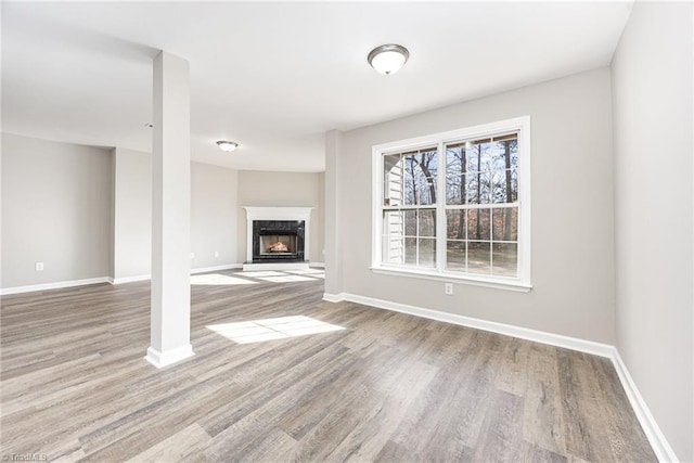 unfurnished living room featuring light wood-type flooring and a premium fireplace