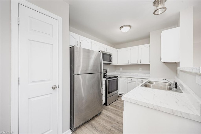 kitchen with sink, white cabinets, light hardwood / wood-style floors, and appliances with stainless steel finishes