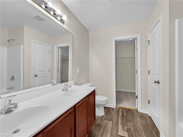 full bath featuring visible vents, toilet, wood finished floors, and a sink