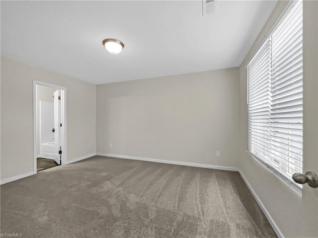 unfurnished room featuring baseboards, carpet floors, and visible vents