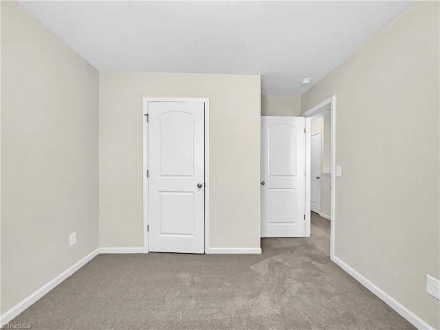 unfurnished bedroom featuring carpet and baseboards