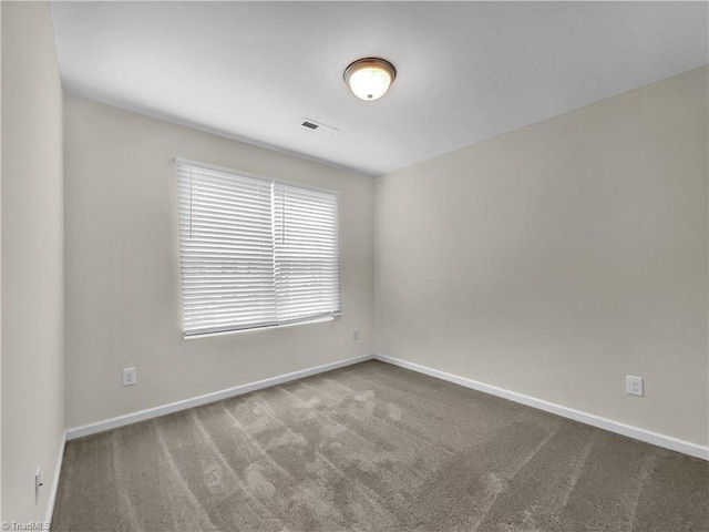 carpeted empty room featuring visible vents and baseboards