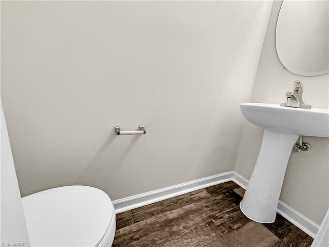 bathroom featuring toilet, wood finished floors, and baseboards