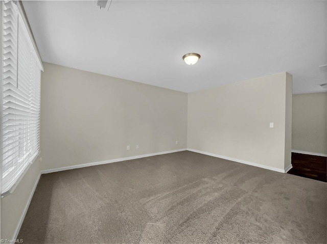 carpeted empty room with baseboards