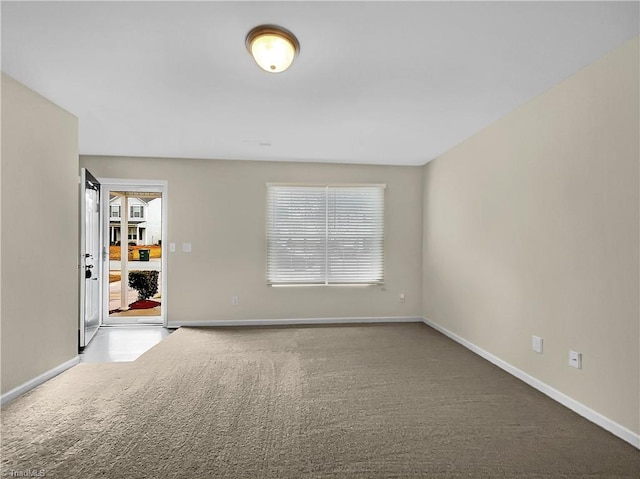 spare room featuring a healthy amount of sunlight, baseboards, and carpet floors