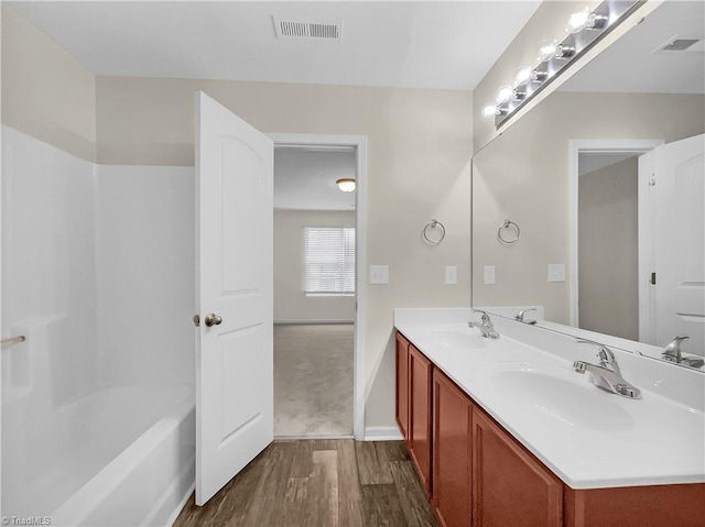 full bathroom with wood finished floors, visible vents, and a sink