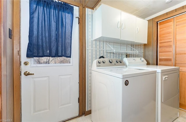 clothes washing area featuring cabinets, independent washer and dryer, and crown molding