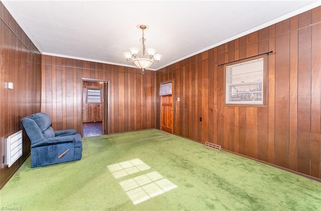 living area with carpet flooring, wooden walls, and an inviting chandelier