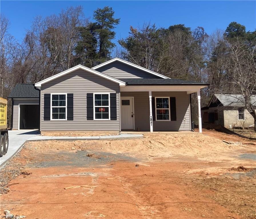 view of front of property with concrete driveway, a garage, and covered porch