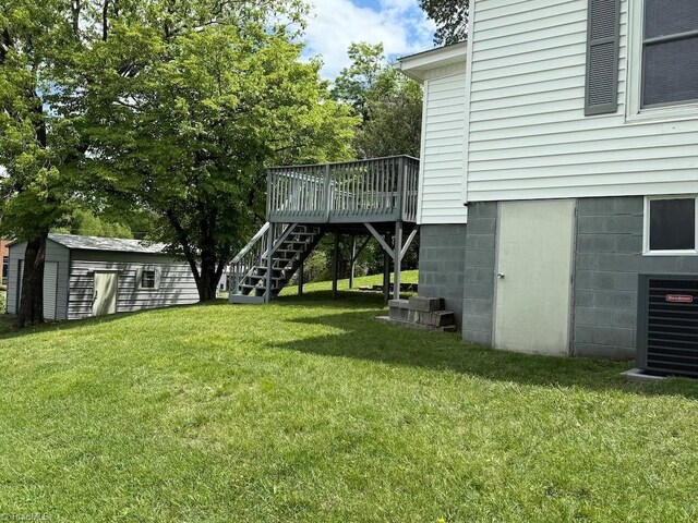 446 Durham St, Mount Airy, NC 27030 - view of grassy yard with stairway, a wooden deck, central AC unit, an outdoor structure, and a storage shed