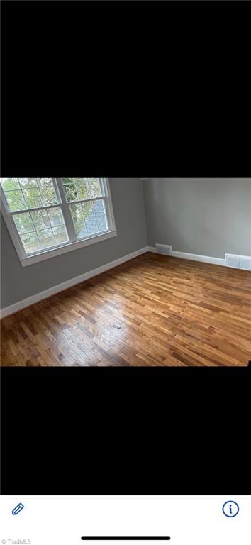 spare room featuring wood-type flooring