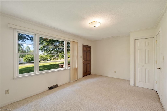 1553 Carson Rd, Pilot Mountain, NC 27041 - unfurnished bedroom with carpet floors, ornamental molding, a textured ceiling, and a closet