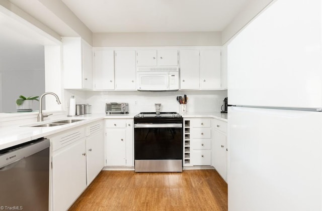 kitchen with appliances with stainless steel finishes, light hardwood / wood-style flooring, sink, and white cabinets