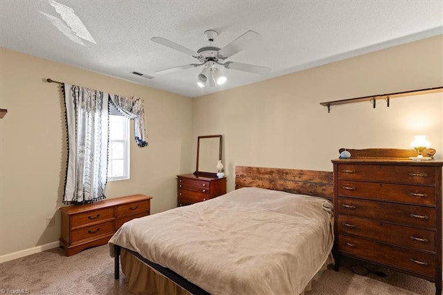 carpeted bedroom with a textured ceiling, a ceiling fan, visible vents, and baseboards