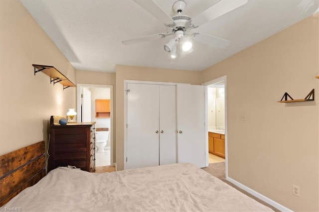 bedroom featuring ceiling fan, a closet, connected bathroom, and baseboards