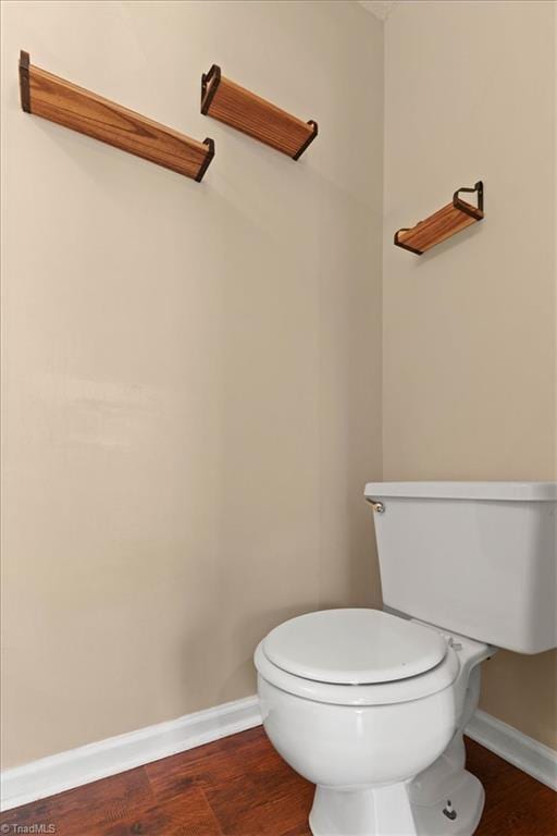 bathroom featuring wood finished floors, toilet, and baseboards