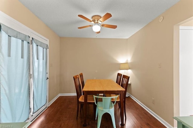 dining area with dark wood-style flooring, ceiling fan, a textured ceiling, and baseboards