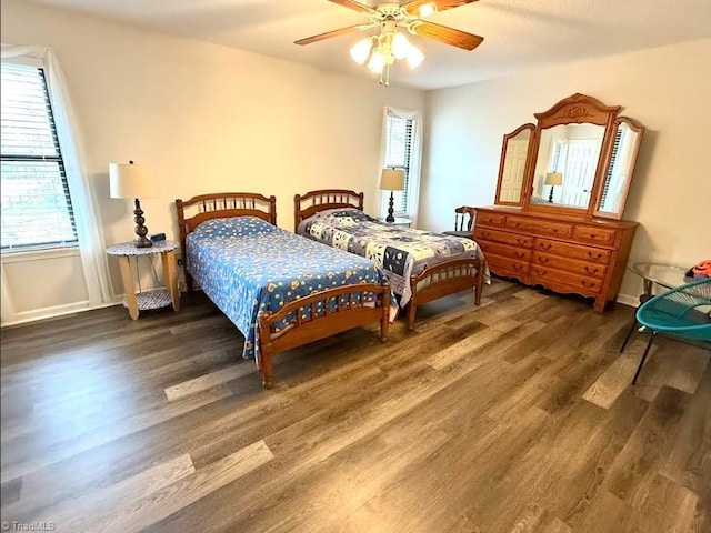 bedroom with multiple windows, wood finished floors, and ceiling fan