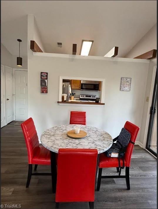 dining area with dark wood-style floors, visible vents, and lofted ceiling